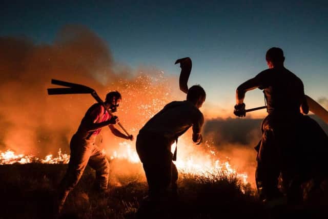 Firefighters battle the flames at Winter Hill in Lancashire