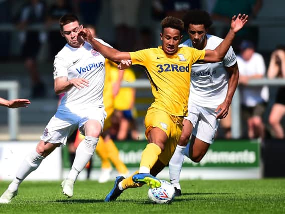 Callum Robinson goes past two AFC Fylde players