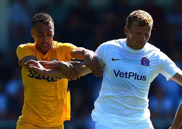 Graham Burke challenges AFC Fylde's Danny Rowe at Mill Farm