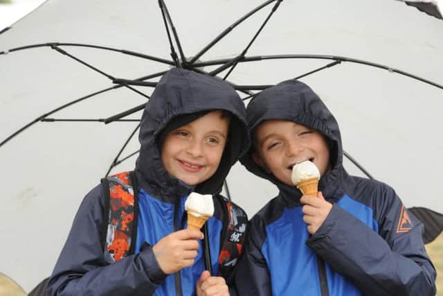 Harry and Oliver Bentham enjoy an ice cream in the rain at the Royal Lancashire Show