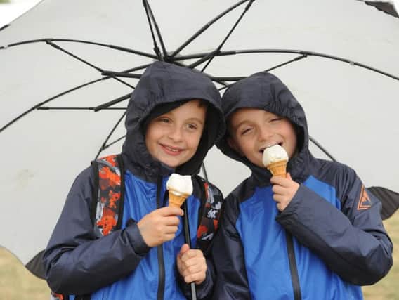 Harry and Oliver Bentham enjoy an ice cream in the rain at the Royal Lancashire Show