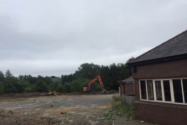 A bulldozer flattens land at the rear of the car park