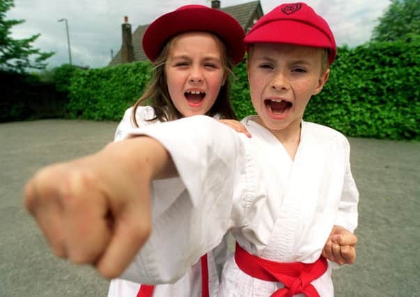 Class 3 pupils, Charlotte Hunter, eight and Robert Cox, eight, from Woodlands School in Ribbleton, Preston, celebrate after the school was promoted as a karate grade A  school after a personal safety promotion