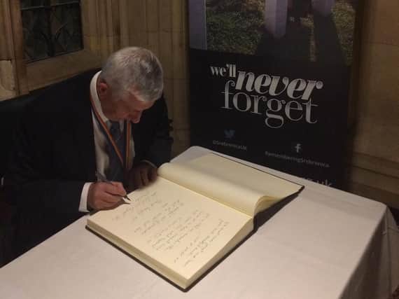 Sir Lindsay signing the Remembering Srebrenica Book of Pledges