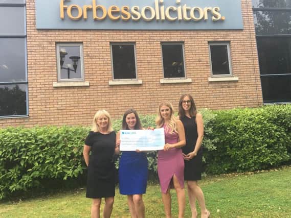 Sharon Froggatt and Natalie Bohane from CARES receive a cheque for 428 from  Abigail Mottram and Rebecca McCann from Forbes.