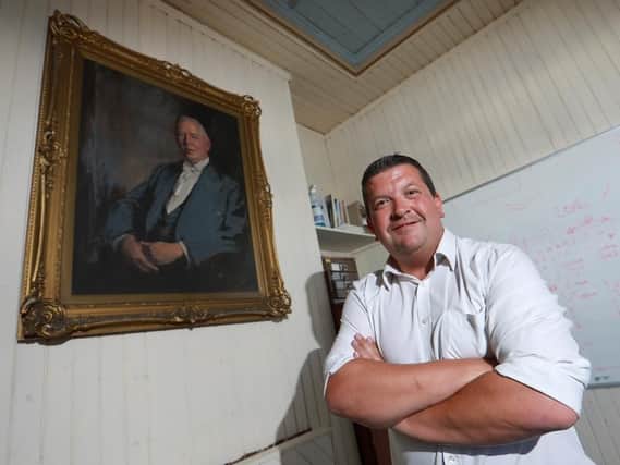 Paul Shinkfield with a portrait of his ancestor and manager Paul Hamlet