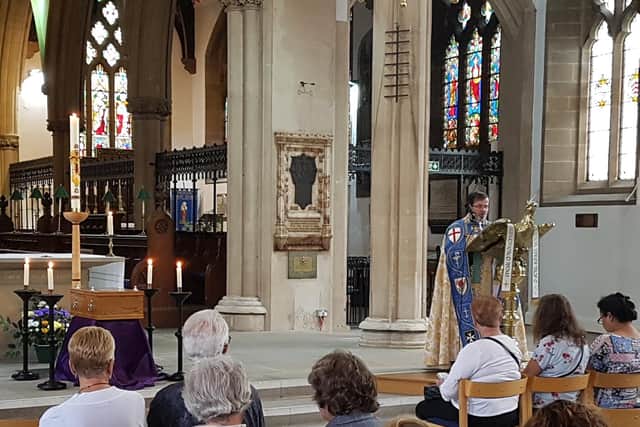 Archdeacon Michael leading the funeral ceremony before the re-burial
