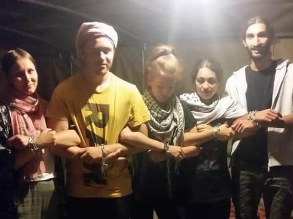 Rio Brennan, in the centre, along with other activists link arms as a sign of solidarity