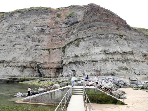 People near the beach at Seaton Garth in Staithes, North Yorkshire where a nine-year-old girl died in a rock fall Wednesday afternoon. Photo credit: Owen Humphreys/PA Wire