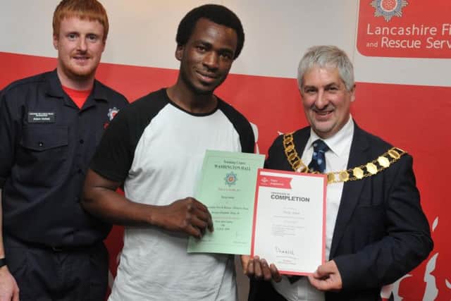 Team leader Adam Hollett from Lancashire Fire and Rescue Service, left, and Mayor of Preston Coun Trevor Hart, right, presents Tarag Adam, centre, with his certificate.