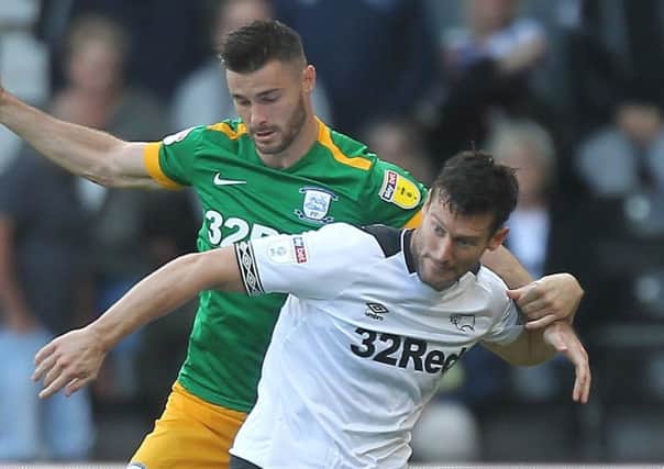 Andrew Hughes  tussles with Derby County's former PNE striker David Nugent