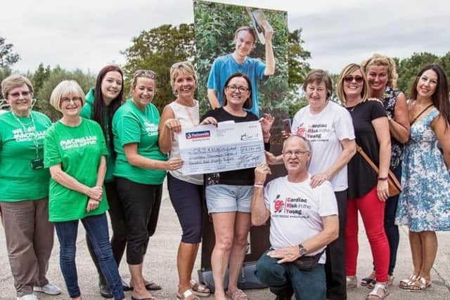 Barry and Paula Hesmondhalgh (wearing CRY t-shirts) being presented with a cheque by Team Shazann. Representatives from Macmillan were also at the presentation