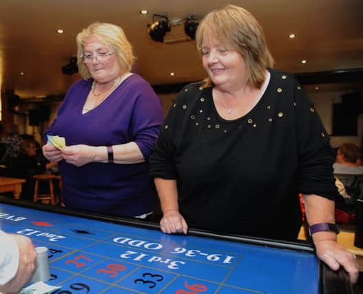 Christine Robinson (left) and Ann Farrell place their bets at the roulette table