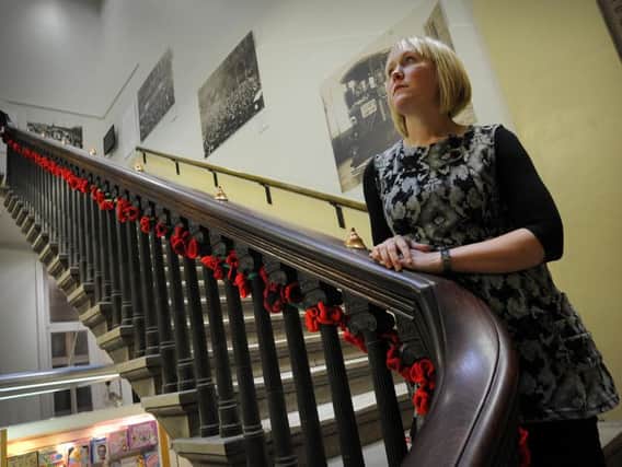 Volunteer co-ordinator Claire Selby pictured in 2014 with hand-knitted poppies decorating the stairs of the Harris Library to mark the centenary of the start of the First World War.