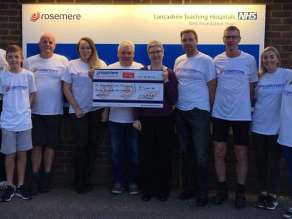 Ian Thompson, centre left, presents Rosemere Cancer Foundations Julie Hesmondhalgh with a donation raised through this years 25th anniversary LUMPS Walk, watched by some of those who also took part