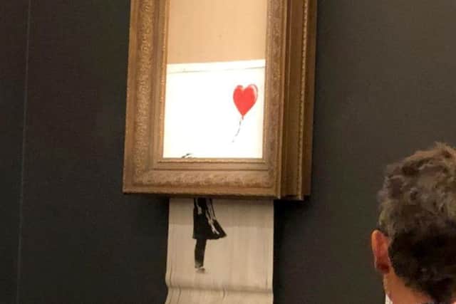 Banksy Girls With Balloon artwork shreds itself moments after being sold for 1m at auction