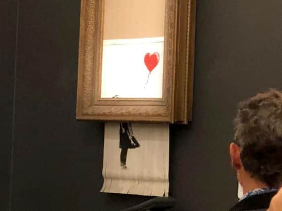 Banksy Girls With Balloon artwork shreds itself moments after being sold for 1m at auction