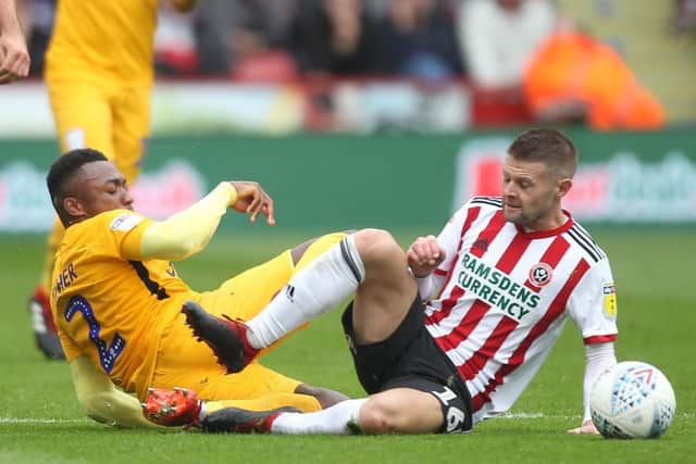 Darnell Fisher challenges Sheffield United's Oliver Norwood