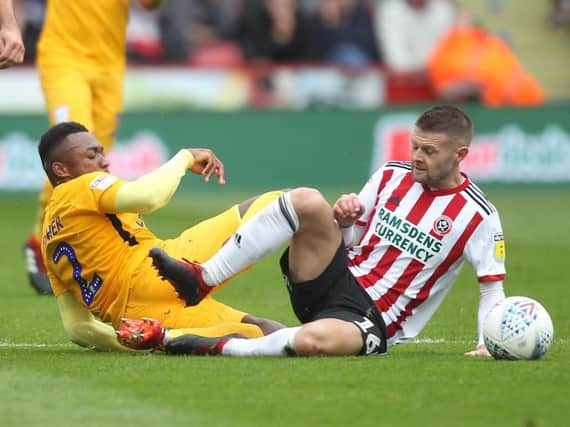 Darnell Fisher challenges Sheffield United's Oliver Norwood