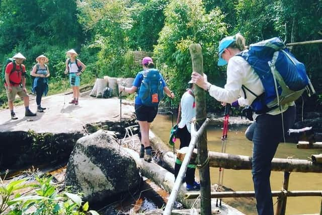 Crossing a tree trunk bridge in Vietnam