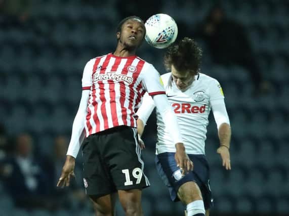 Preston North End's Ben Pearson competes for a header with Brentford's Romaine Sawyers