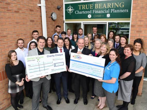 Directors of True Bearing and their staff handing over their cheque to Derian and Brian House childrens hospices