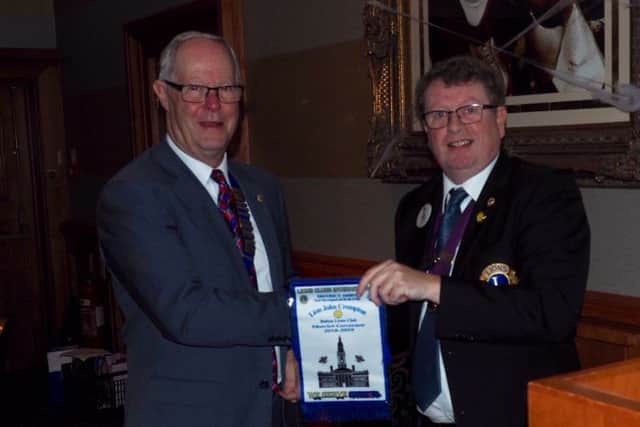 This years Lion President David Farmer ( left) receiving the District Governors personal bannerette from DG John Crompton.