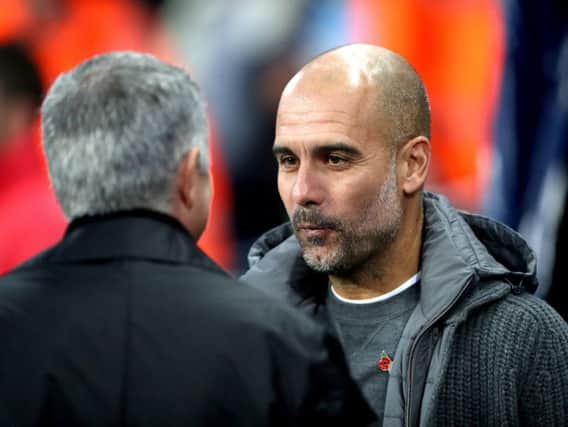 Manchester City's Pep Guardiola with Manchester United's Jose Mourinho (left) during the Premier League match at the Etihad Stadium, Manchester.