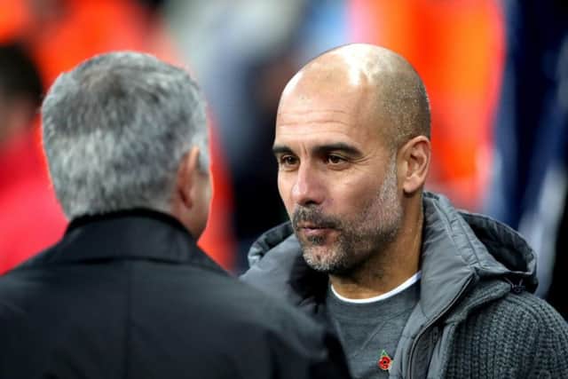 Manchester City's Pep Guardiola with Manchester United's Jose Mourinho (left) during the Premier League match at the Etihad Stadium, Manchester.