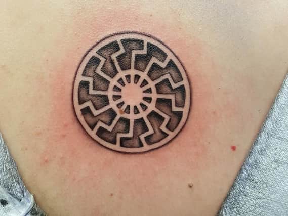 A tattoo of the black sun on the back of Claudia Patatas