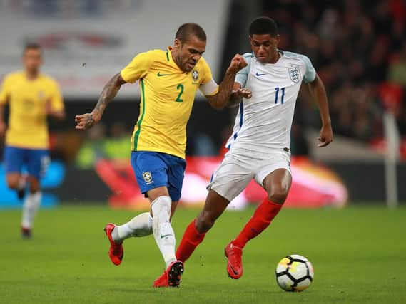 Brazil's Dani Alves (left) and England's Marcus Rashford battle for the ball during the Bobby Moore Fund International match at Wembley Stadium, London.