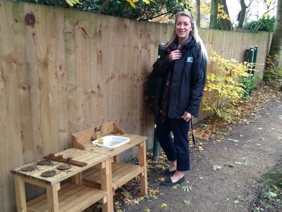 Lizzy Krauss, of Playforce, presents the mud kitchen to Derian House