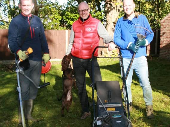 Duncan Royale, Dave Graham and Paul Norris with Jai the dog helping in the grounds of Rainbow House