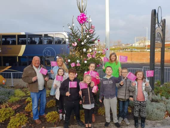 Coun Danny Gee, Janet Ellison, staff and children from Inspire Youth Zone with the  Christmas tree to encourage more ladies to attend breast screening appointments.