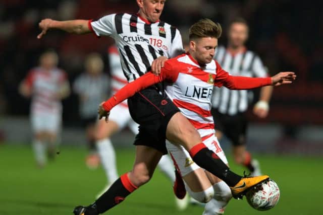 Doncaster's Alfie May is challenged by Chorley's Scott Leather in their FA Cup replay in November