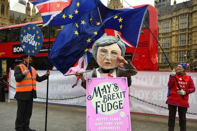 A demonstrator dressed as Theresa May sells Brexit Fudge in Old Palace Yard, Westminster