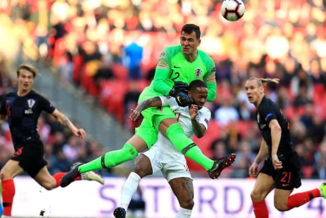 Croatia goalkeeper Lovre Kalinic (left) and England's Raheem Sterling (right) battle for the ball during the UEFA Nations League