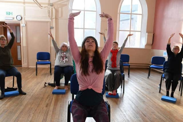 Madeline Diaz Meiners teaching participants chair yoga at Park Road Unitary Chapel Hall, Chorley