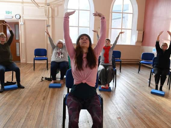 Madeline Diaz Meiners teaching participants chair yoga at Park Road Unitary Chapel Hall, Chorley