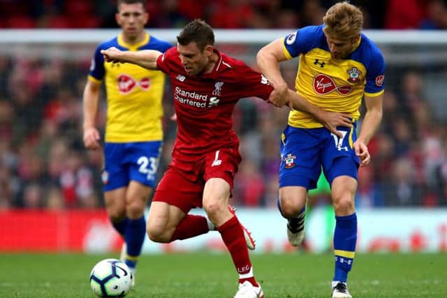 Liverpool's James Milner (centre) and Southampton's Stuart Armstrong (right) battle for the ball during the Premier League match at Anfield