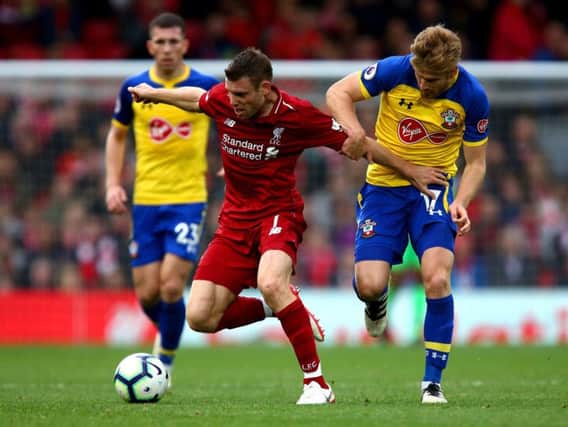 Liverpool's James Milner (centre) and Southampton's Stuart Armstrong (right) battle for the ball during the Premier League match at Anfield