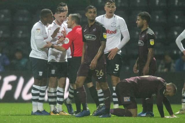 Preston North End's Darnell Fisher and Alan Browne plead a case for team-mate Josh Earl after he is sent-off by referee Keith Stroud against Swansea