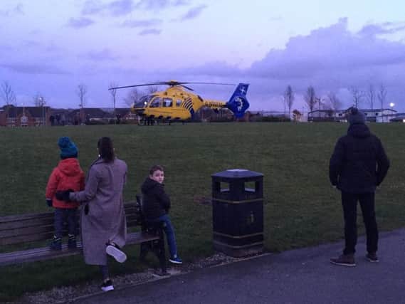 Residents watch on as an air ambulance landed in Buckshaw Village