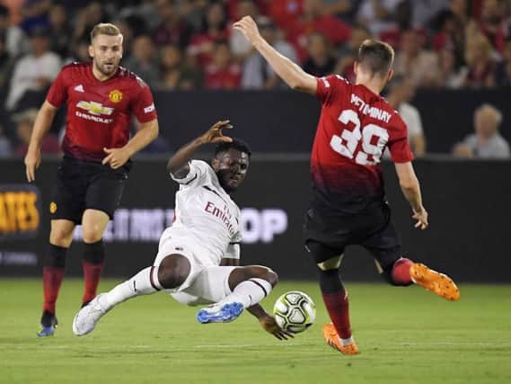 AC Milan midfielder Franck Kessie, center, tries to kick past Manchester United midfielder Scott McTominay