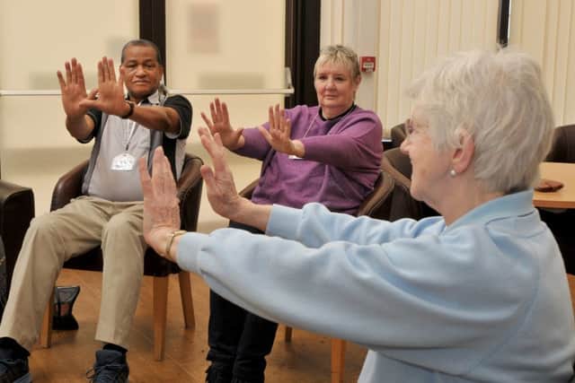 Helper Joan Moran (front, in blue) leads group members in sitting exercise at the Gentle Approach to Cancer Centre.