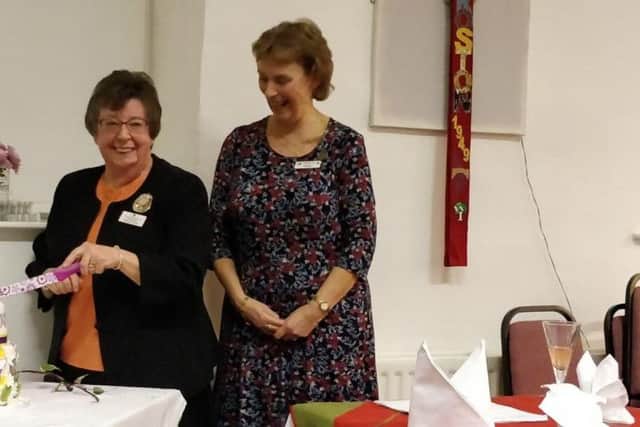 Chairman of Lancashire Federation of WIs, Jackie Hobson and Debbie Reynolds President of Croston WI cutting the cake to celebrate Croston WI's 70th anniversary
