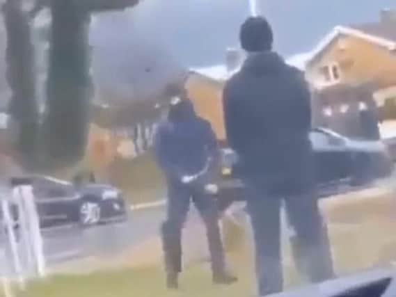An image from the video showing masked men in Leyland