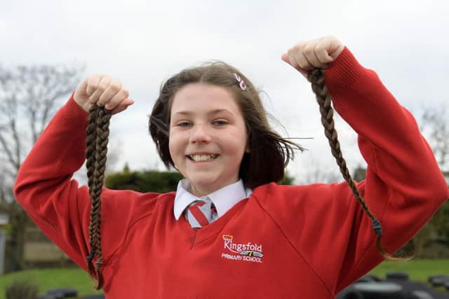 Toni-Lea holds her lovely long locks in her hands after they have been lopped for charity