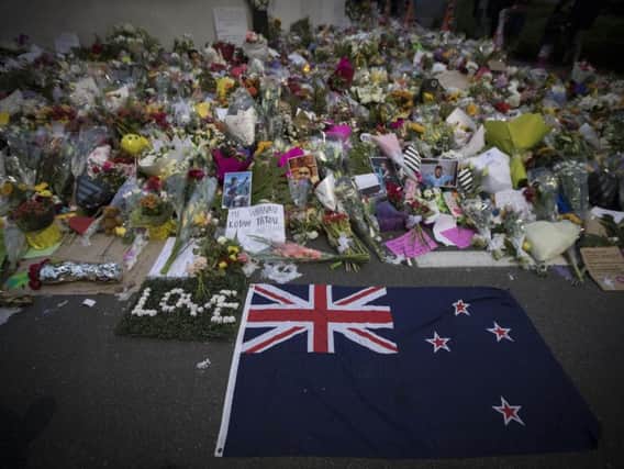 Mourners lay flowers on a wall outside the Al Noor mosque in Christchurch, New Zealand