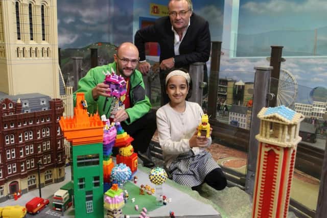 Winner of LEGOLAND Discovery Centres Cities of the Future competition, seven-year-old Saira Ali, with lead judge and futurologist Richard Watson and LEGOLAND Master Model Builder James Windle.